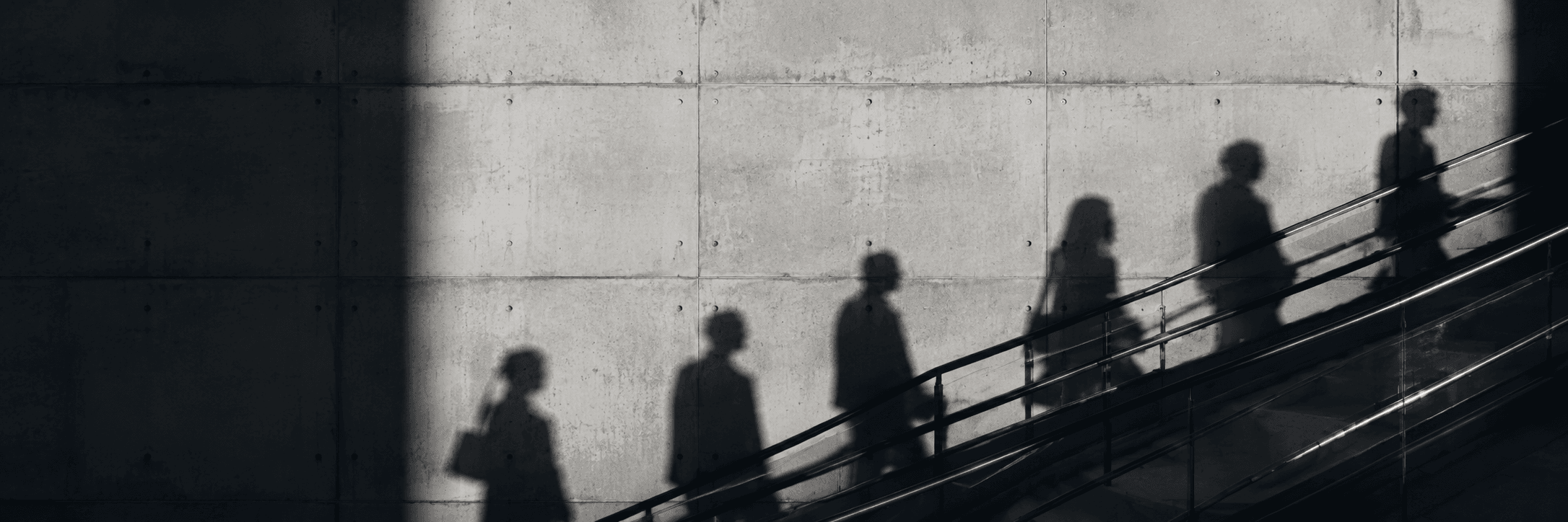 People in motion, long shadows across a concrete stairway